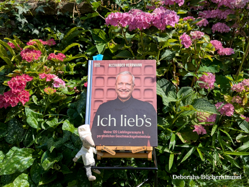 Das Kochbuch "Ich lieb's" vor blumigen Hintergrund im Garten.